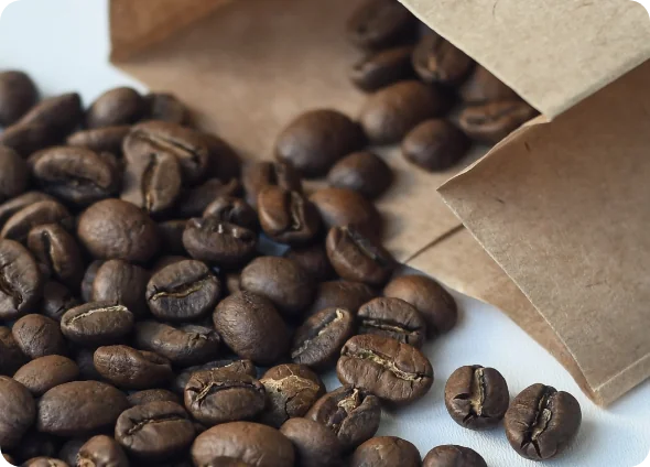 Coffee Beans spilling out of a recyclable paper bag