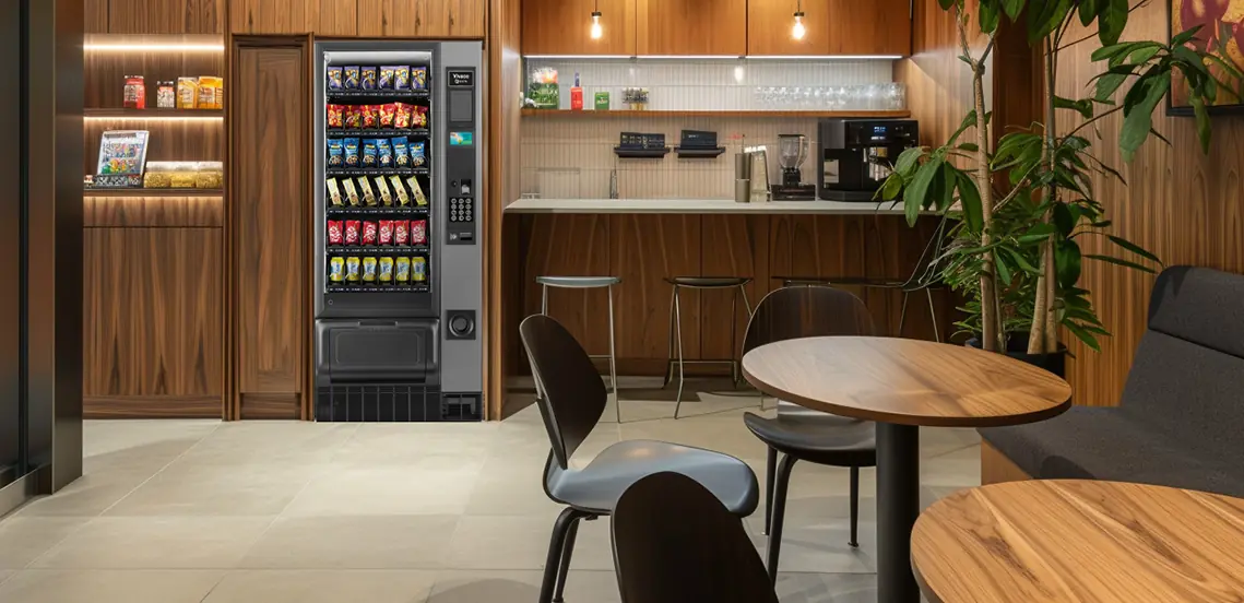 A wooden office kitchen featuring a Necta snack and drink vending machine