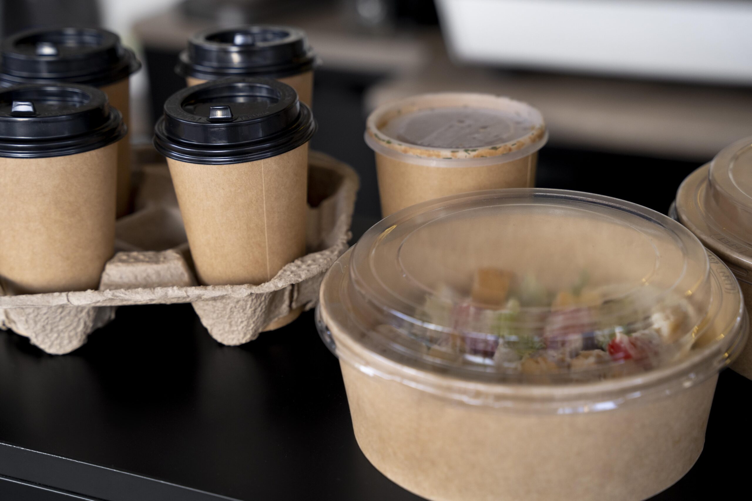 Recyclable containers holding a salad and takeaway coffees